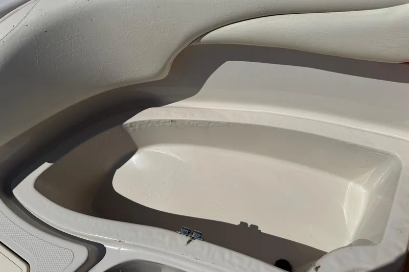 Slide: The Image of Interior of a 2008 Tahoe 195 boat, featuring white seating and storage compartment. - 19