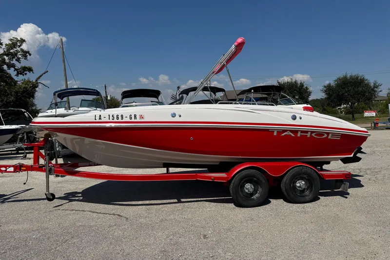Slide: The Image of 2008 Tahoe 195 boat on trailer, red and white design, parked outdoors under clear sky. - 3