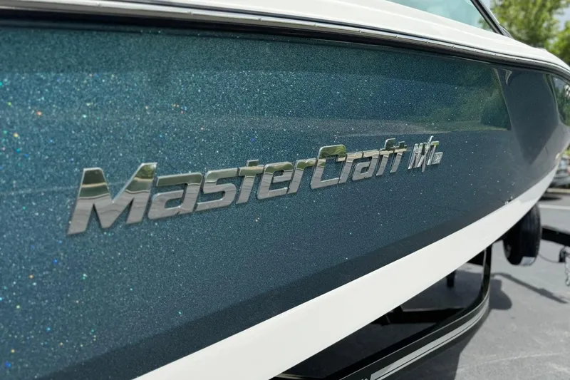 Slide: The Image of 2025 MasterCraft NXT24 boat with metallic blue finish and logo detail. - 14