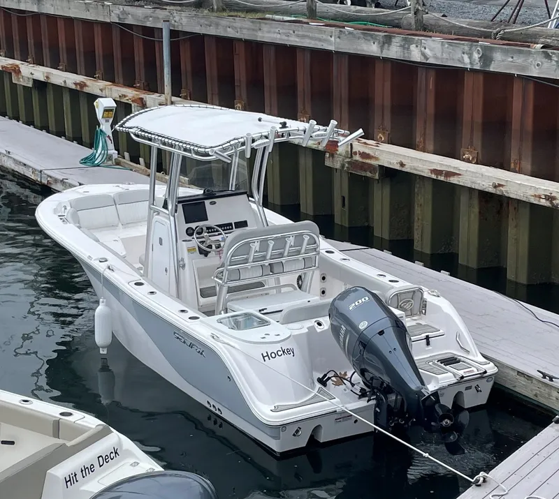Slide: The Image of 2023 Sea Fox 228 Commander boat docked, featuring a sleek design and powerful outboard motor. - 3