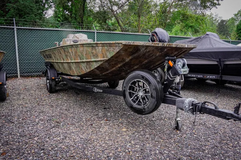 Slide: The Image of 2026 G3 17SC boat on trailer, camo design, parked outdoors. - 2