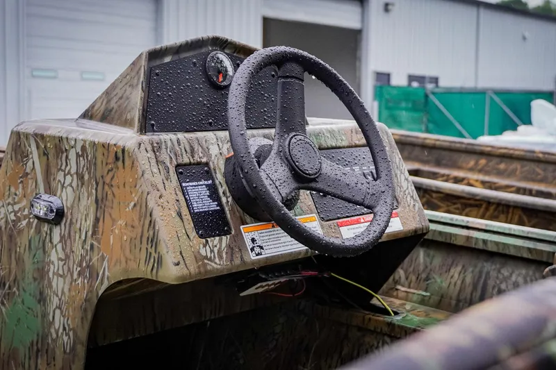 Slide: The Image of Camouflage-patterned G3 17SC boat console with steering wheel, 2026 model, wet from rain. - 6