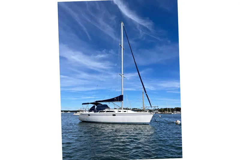 Slide: The Image of 2003 Catalina 320 sailboat on calm water under a clear blue sky. - 0