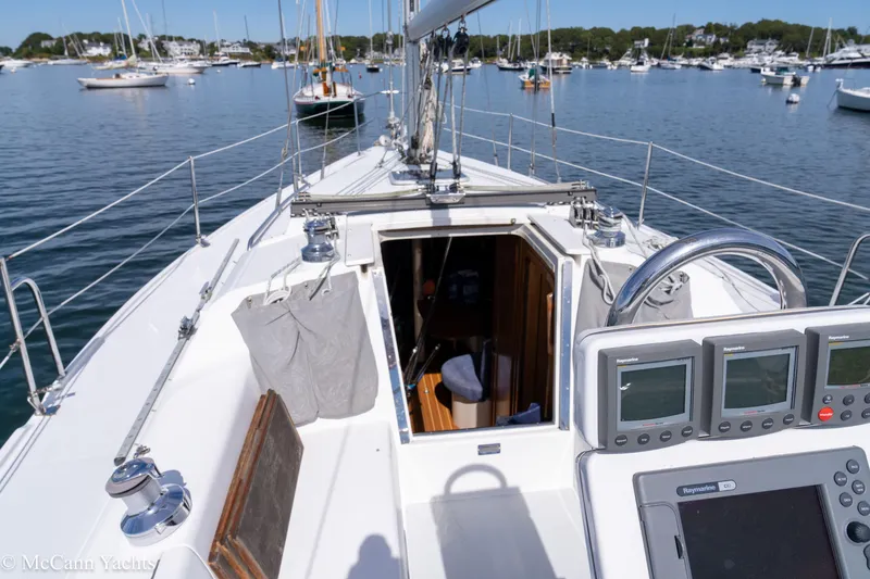Slide: The Image of 2003 Catalina 320 sailboat cockpit with navigation instruments, open cabin, and marina view. - 10