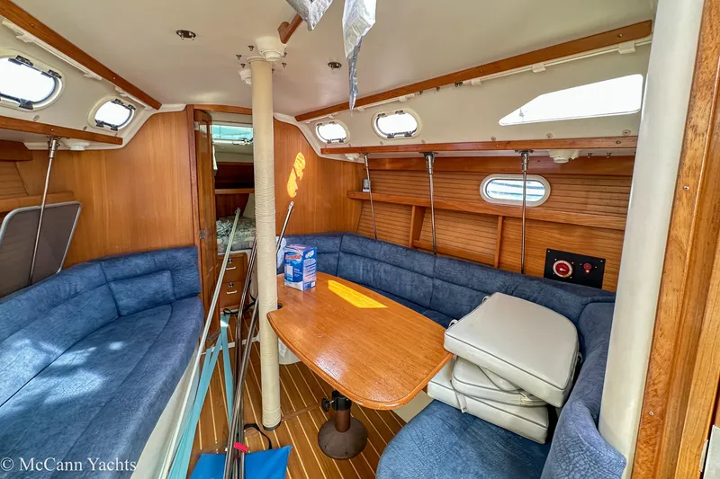 Slide: The Image of Interior of 2003 Catalina 320 yacht with blue seating and wooden table. - 13