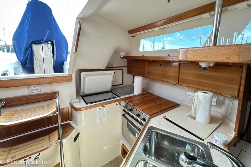 Slide: The Image of Interior of 2003 Catalina 320 yacht kitchen with wooden cabinets and stainless steel sink. - 14