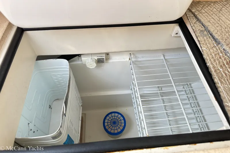 Slide: The Image of Interior view of a 2003 Catalina 320 yacht's storage compartment with wire shelving. - 16