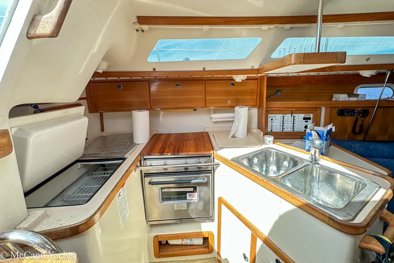 Slide: The Image of Interior of 2003 Catalina 320 yacht kitchen with sink, stove, and wooden cabinetry. - 18