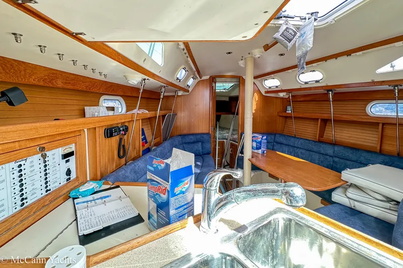 Slide: The Image of Interior of a 2003 Catalina 320 sailboat with wooden finishes and blue seating. - 20