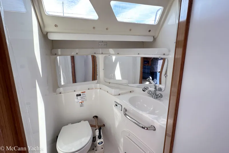 Slide: The Image of Bathroom interior of 2003 Catalina 320 yacht with toilet, sink, and mirror. - 23