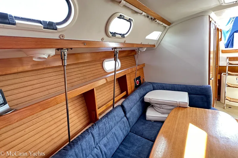 Slide: The Image of Interior of 2003 Catalina 320 yacht with blue seating and wooden accents. - 26