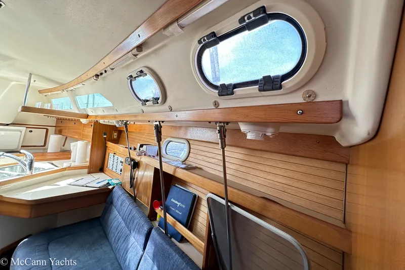 Slide: The Image of Interior of 2003 Catalina 320 yacht with wooden paneling and seating area. - 27