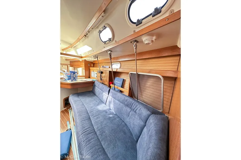 Slide: The Image of Interior of 2003 Catalina 320 yacht with blue sofa and wooden accents. - 28