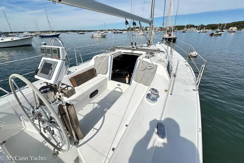 Slide: The Image of 2003 Catalina 320 sailboat cockpit with navigation equipment, docked in a serene marina. - 30