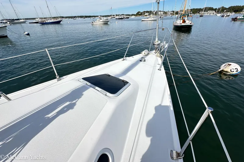 Slide: The Image of Deck view of 2003 Catalina 320 sailboat in a serene marina setting. - 32