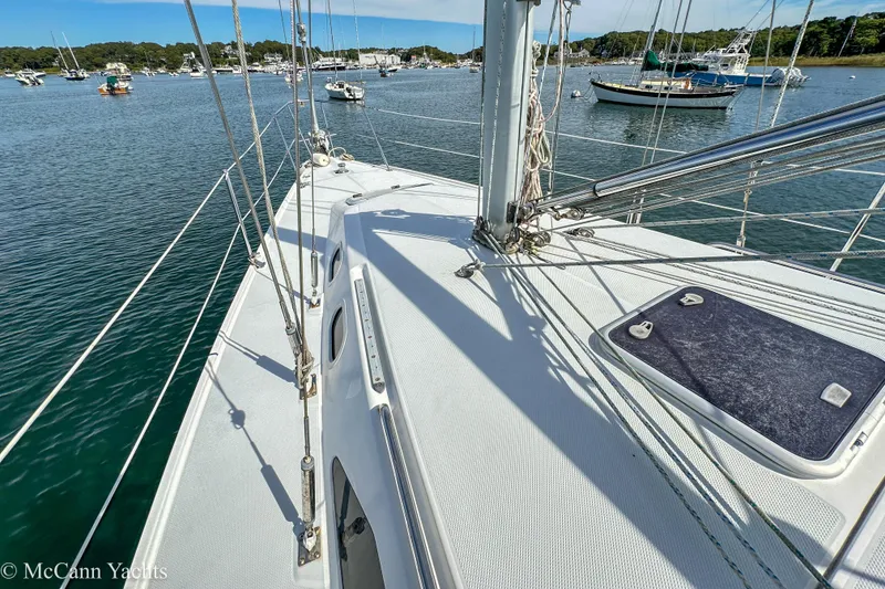 Slide: The Image of Deck view of a 2003 Catalina 320 sailboat in a serene harbor setting. - 33