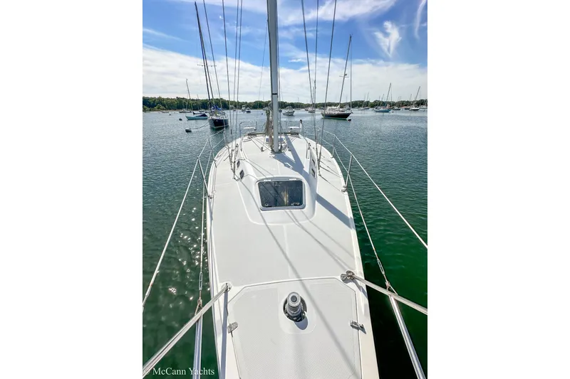 Slide: The Image of Sailboat Catalina 320, 2003 model, docked in a serene marina under a blue sky. - 35