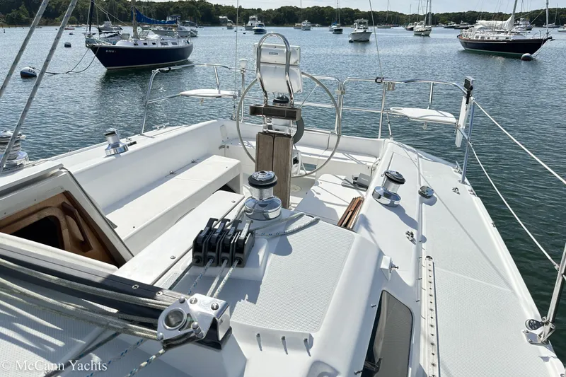 Slide: The Image of 2003 Catalina 320 sailboat cockpit with steering wheel, moored in a scenic harbor. - 36