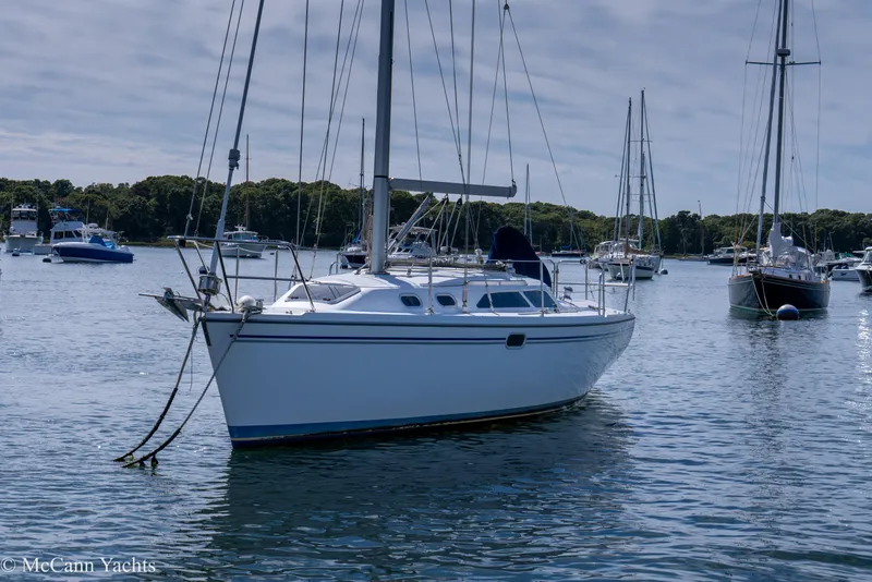 Slide: The Image of Sailboat Catalina 320, 2003 model, anchored in a serene harbor with other boats. - 4