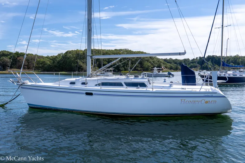 Slide: The Image of 2003 Catalina 320 sailboat named "Honey Comb" anchored in a scenic harbor. - 46