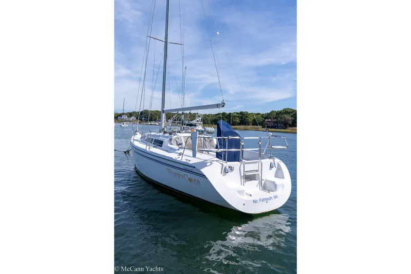 Slide: The Image of Catalina 320 sailboat, 2003 model, docked in calm waters under a clear sky. - 49