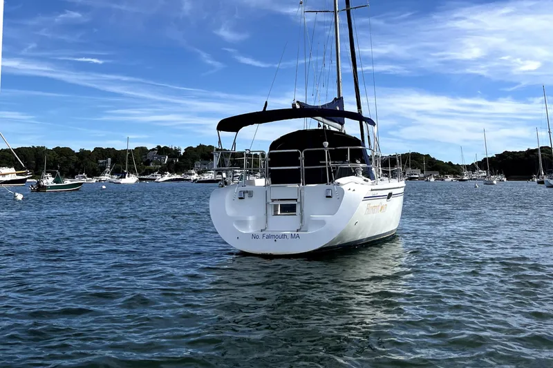 Slide: The Image of Sailboat Catalina 320, 2003 model, anchored in a scenic harbor with clear blue skies. - 5