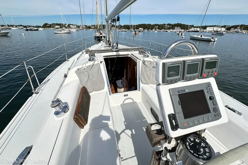 Slide: The Image of 2003 Catalina 320 sailboat cockpit with navigation instruments, moored in a scenic harbor. - 8