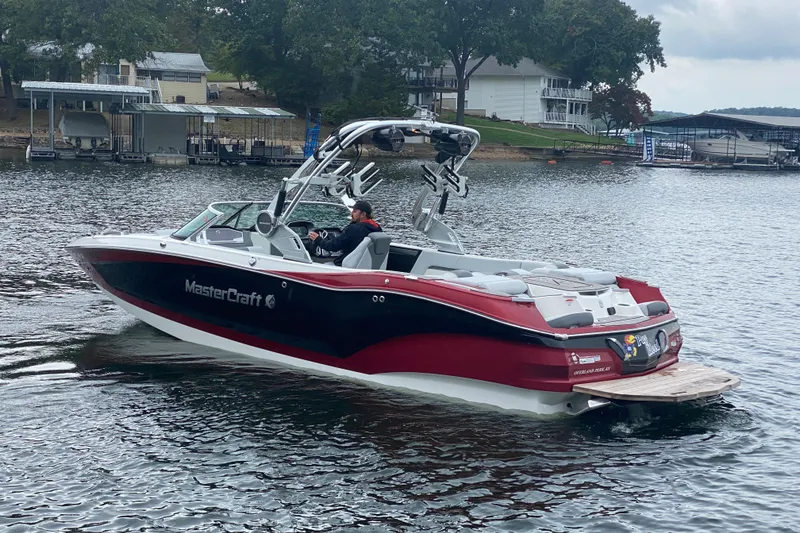 Slide: The Image of 2019 MasterCraft X24 boat on a lake near docks and houses. - 3