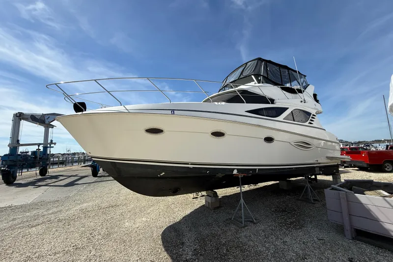 The Image of 2005 Silverton 38 Sport Bridge yacht on dry dock under clear blue sky. - 0