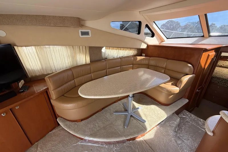 Slide: The Image of 2005 Silverton 38 Sport Bridge interior with leather seating and dining table. - 11