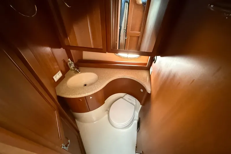 Slide: The Image of 2005 Silverton 38 Sport Bridge bathroom with wooden cabinetry and compact design. - 15