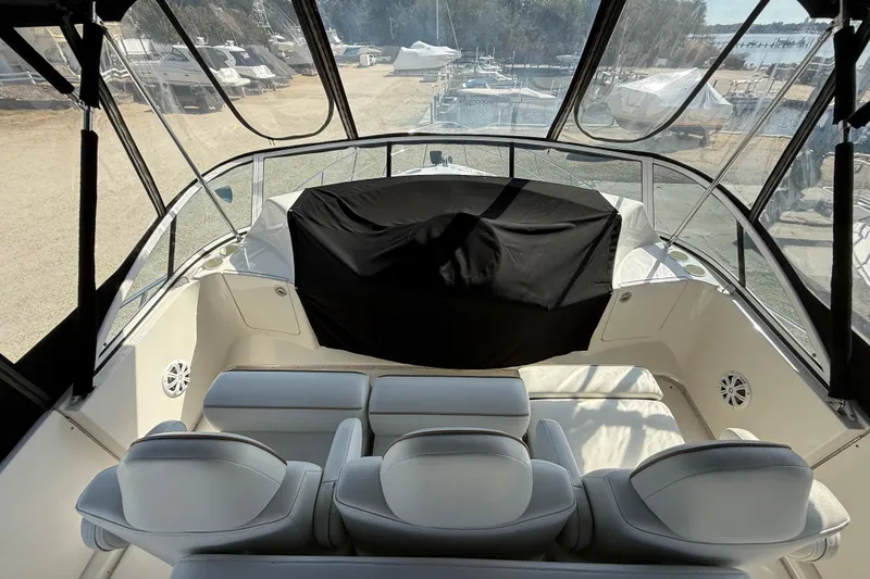 Slide: The Image of 2005 Silverton 38 Sport Bridge interior with seating and covered helm, docked at marina. - 19