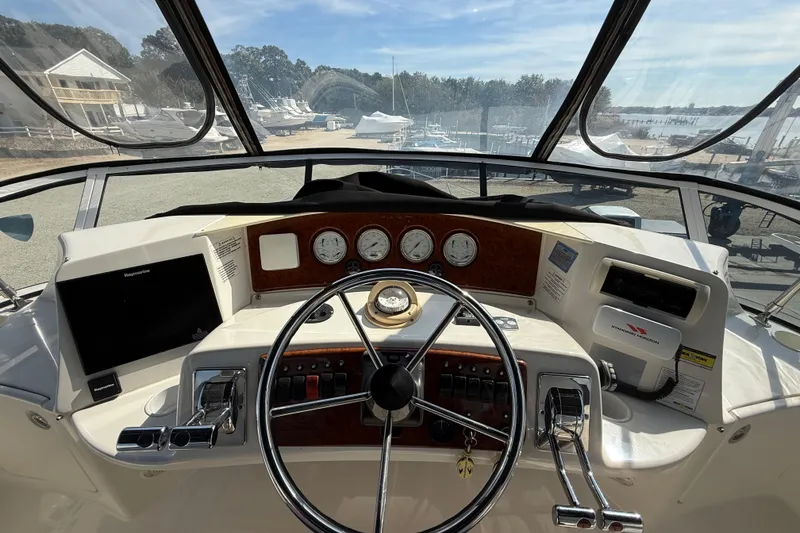 Slide: The Image of 2005 Silverton 38 Sport Bridge helm with steering wheel, gauges, and navigation equipment. - 20