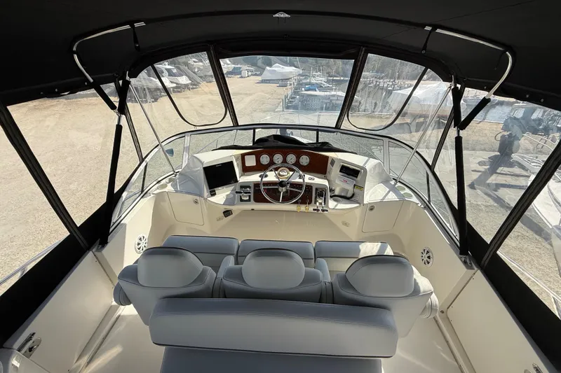Slide: The Image of 2005 Silverton 38 Sport Bridge yacht interior with helm, steering wheel, and seating. - 24