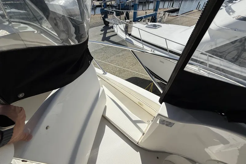 Slide: The Image of 2005 Silverton 38 Sport Bridge yacht docked, featuring sleek design and spacious deck area. - 26