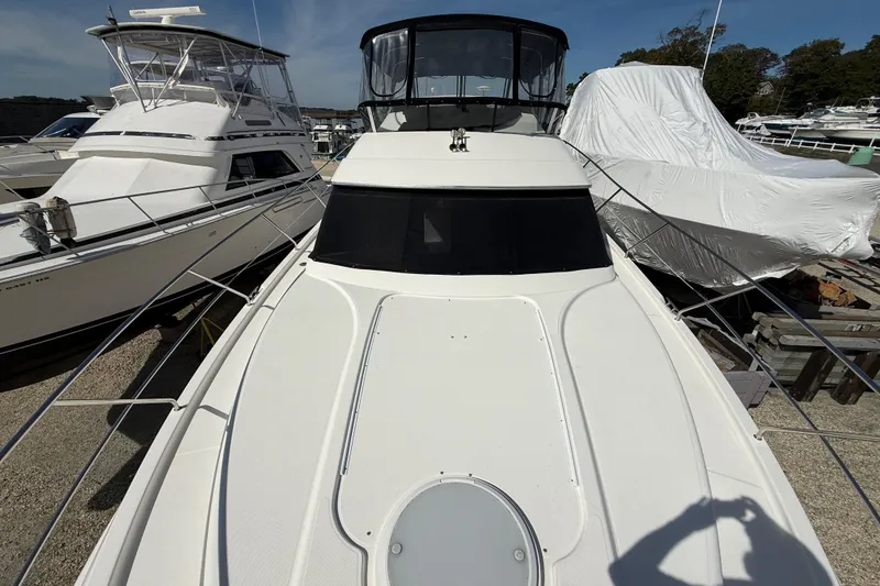 Slide: The Image of 2005 Silverton 38 Sport Bridge yacht docked, surrounded by other boats, under clear skies. - 29