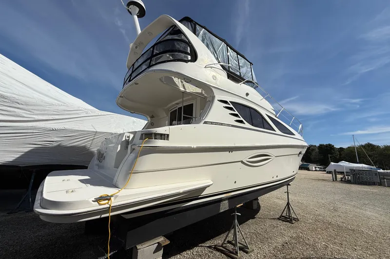 Slide: The Image of 2005 Silverton 38 Sport Bridge yacht on dry dock under clear blue sky. - 3