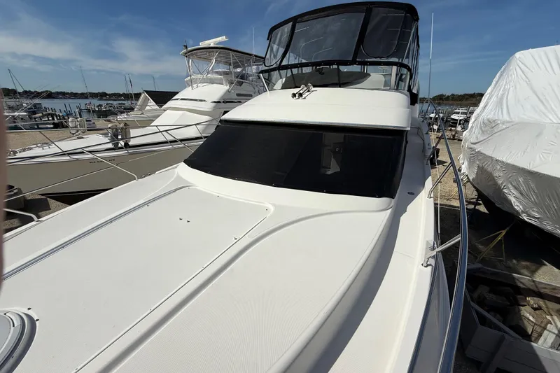 Slide: The Image of 2005 Silverton 38 Sport Bridge yacht docked at a marina under clear skies. - 31