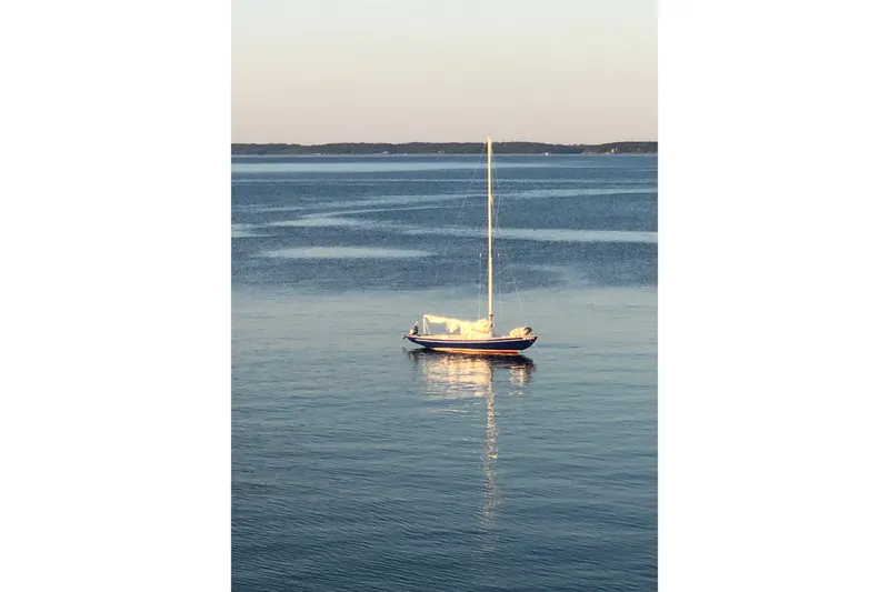 The Image of Sailboat on calm water, Bluenose One Design, 1970 model, reflecting sunset light. - 1