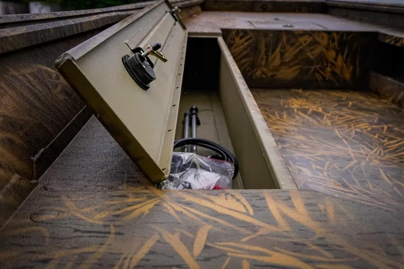 Slide: The Image of Open storage compartment in G3 17DK boat, showcasing camo design, 2026 model. - 13