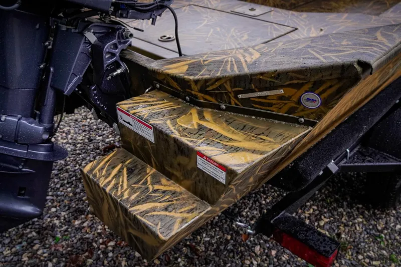 Slide: The Image of Camouflage-patterned steps on a 2026 G3 17DK boat, with visible motor and trailer. - 7