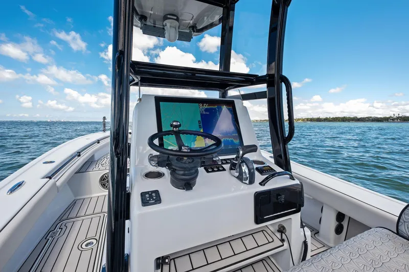 Slide: The Image of 2020 Barker Boatworks 26 Open console with steering wheel and navigation screen on open water. - 24