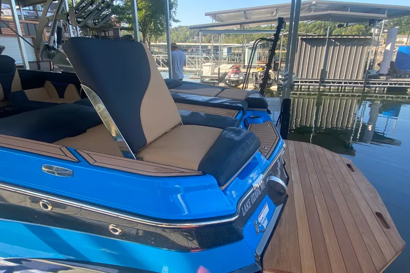 Slide: The Image of 2021 MasterCraft XT25 boat docked, featuring blue and tan seating. - 10