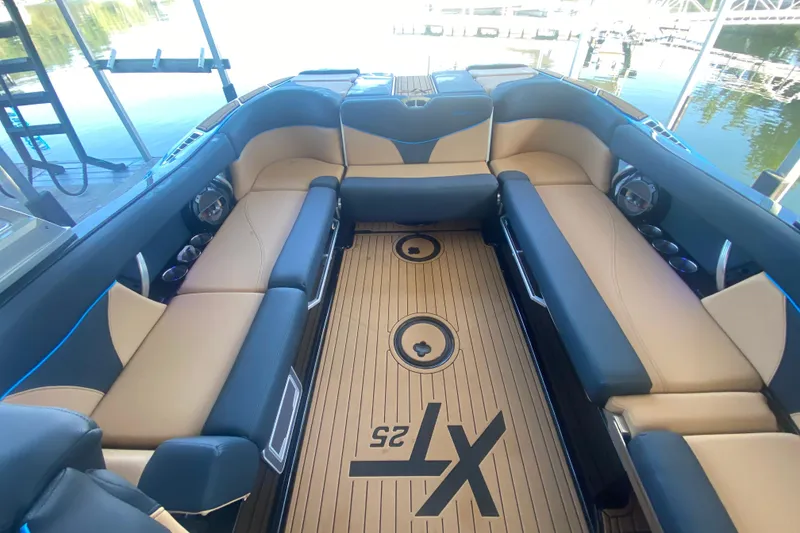 Slide: The Image of 2021 MasterCraft XT25 boat interior with luxurious seating and teak flooring. - 14