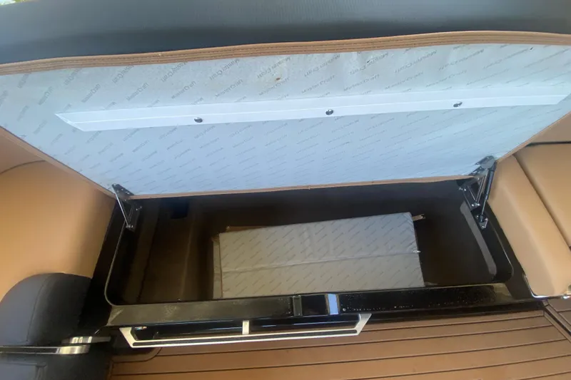 Slide: The Image of Open storage compartment in 2021 MasterCraft XT25 boat, showcasing interior design and materials. - 18