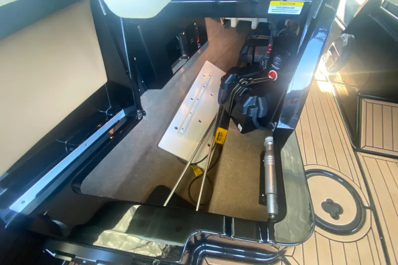 Slide: The Image of 2021 MasterCraft XT25 boat interior storage compartment with visible battery and wiring. - 21