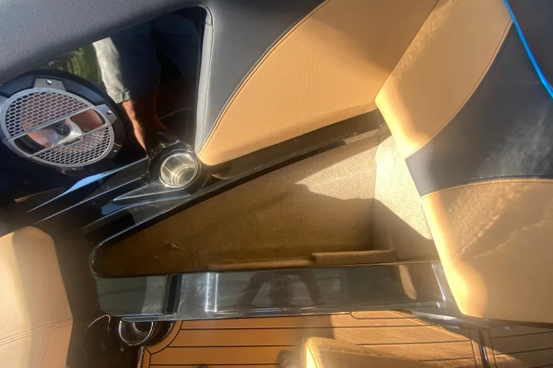 Slide: The Image of Interior of 2021 MasterCraft XT25 boat with tan and black seating, speaker, and cup holder. - 30