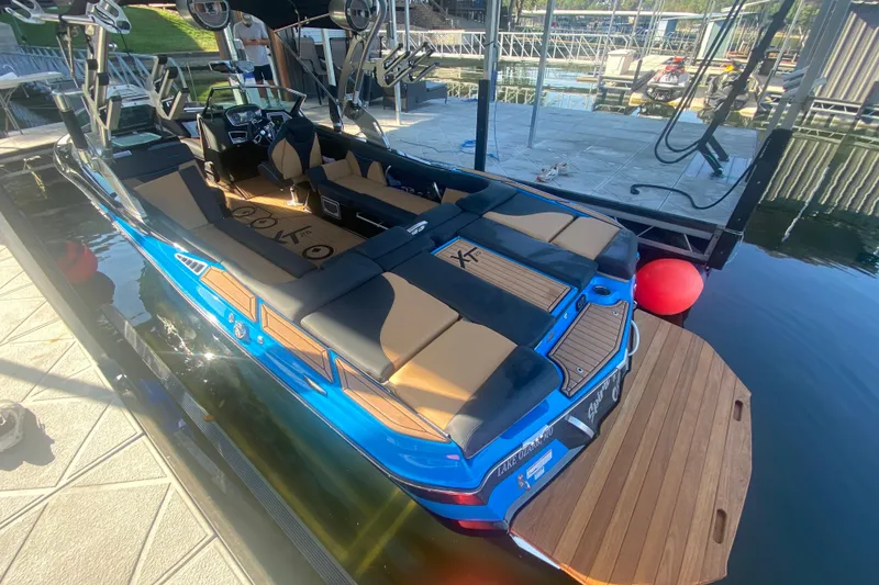 Slide: The Image of 2021 MasterCraft XT25 boat docked, featuring sleek design and spacious seating. - 32