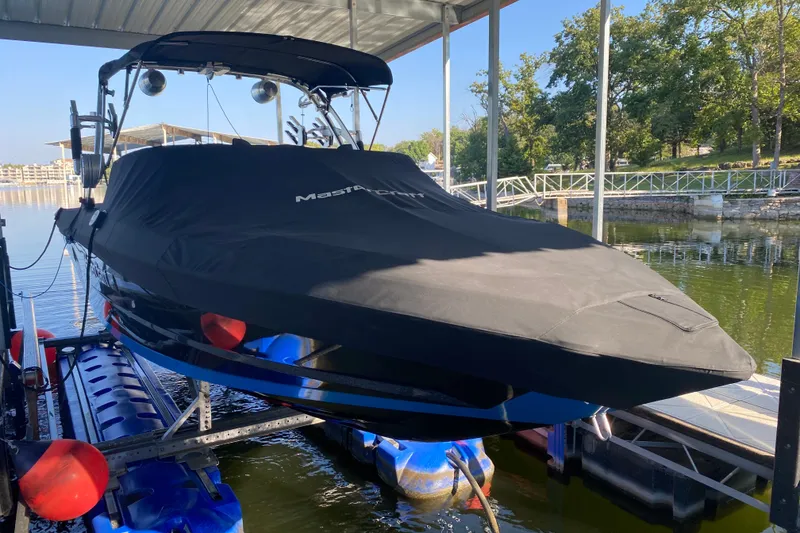 Slide: The Image of 2021 MasterCraft XT25 boat covered and docked on a sunny day. - 33