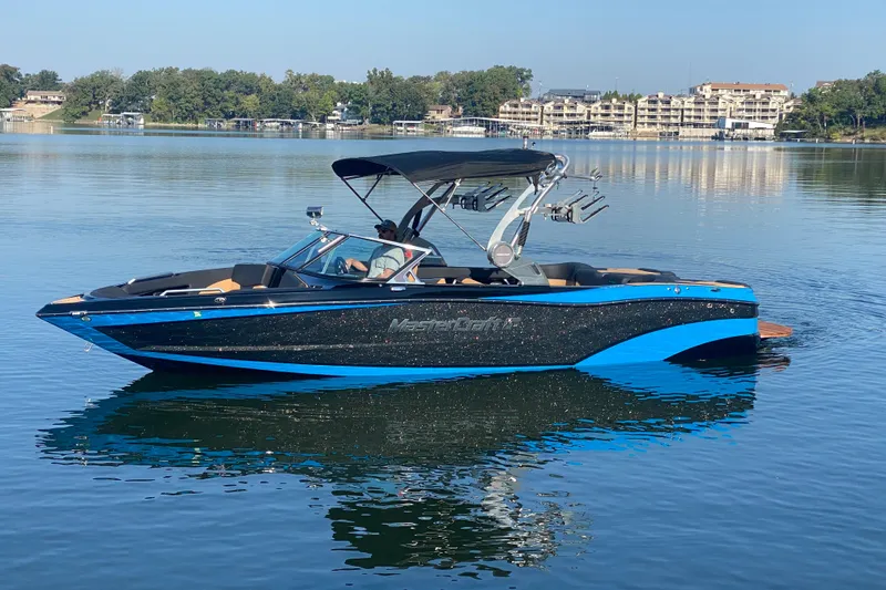 Slide: The Image of 2021 MasterCraft XT25 boat on calm lake with scenic background. - 4
